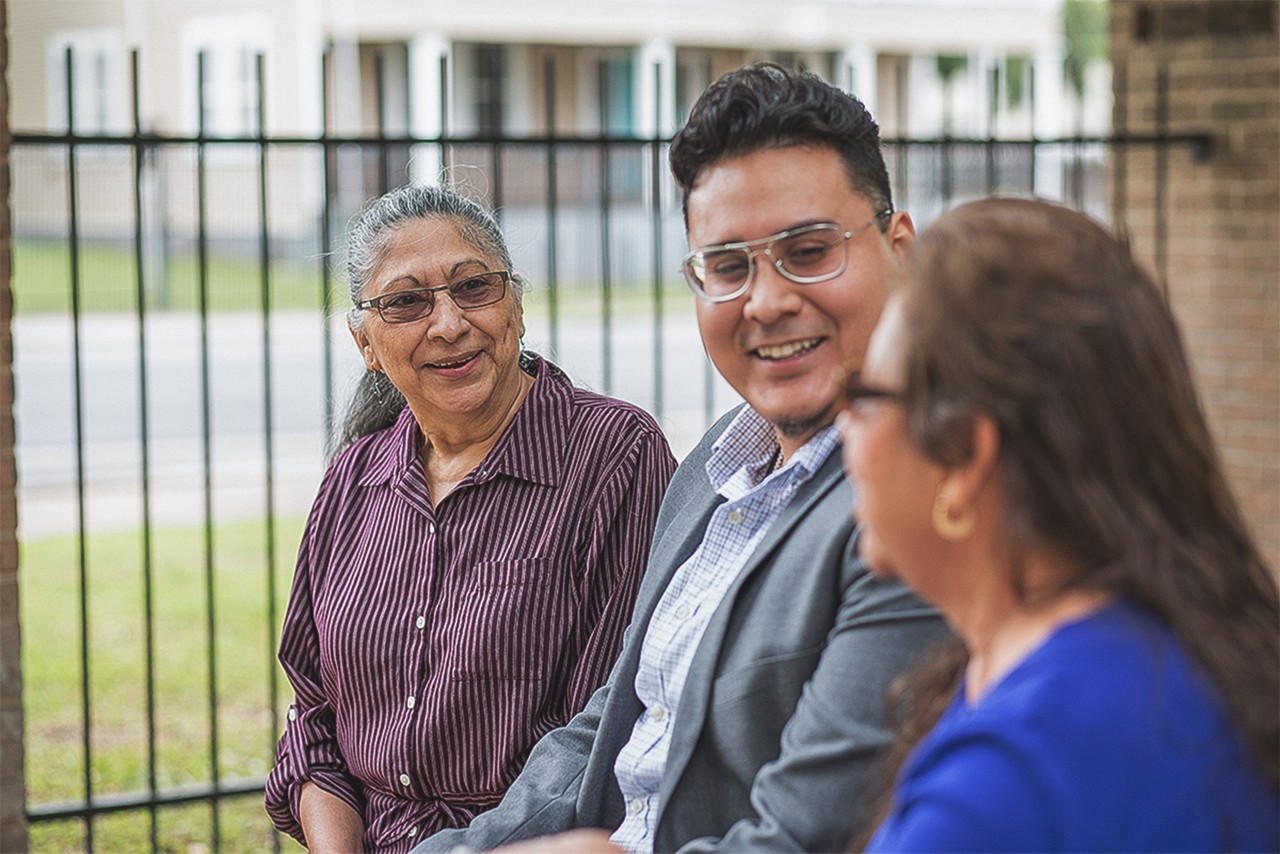 San Antonio, 2019. Silvia Gonzales (right) received assistance with help transferring a house title that she was otherwsie unable to naviagte heerself. She was in danger of losing the house and the financial benefits that come with it as she could not afford a lawyer. 
Mary Carrillo's (left) parents passed away and left their house in Mary's brothers name. When this brother passed away Mary was left in the dark on what to do. MAUC helped transfer the title to her name.  
Daniel Ibarra (left) was originally born in Mexico and came to the United States when he was 2. He was undocumented until age 8. Daniel was awarded a college scholorship program through MAUC and interend there for 3 summers. He now is a full time employee at MAUC and has the title of Housing Coordinater. He teaches several classes for the organization as well. 
MAUC stands for Mexican American Unity Council.