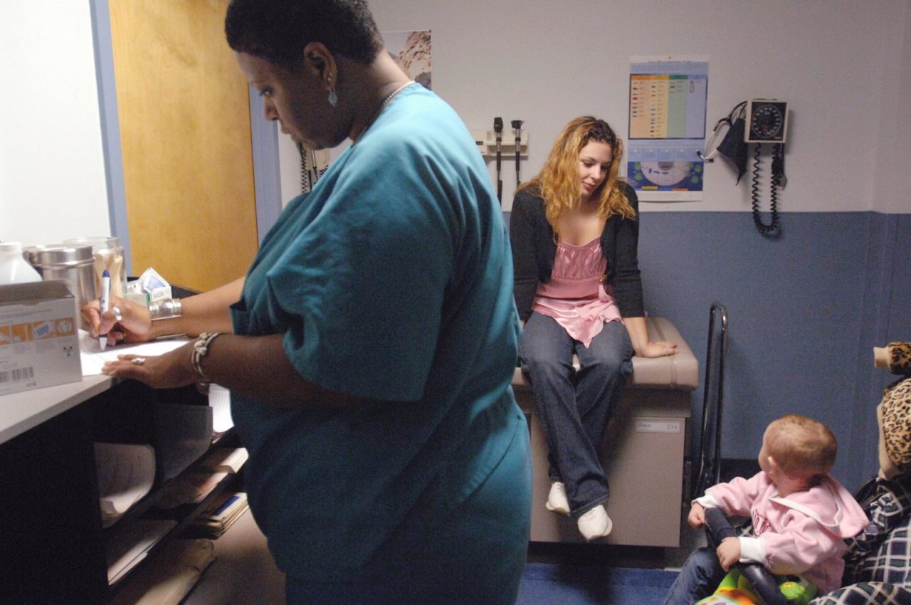 Nurse, Terri Crampton, checks out Tina for intake process into the drug program, at Brandywine Counseling, Inc., a substance abuse treatment center in Wilmington, DE. Tina's daughter Cheyenne waits in her stroller.  Paths to Recovery.