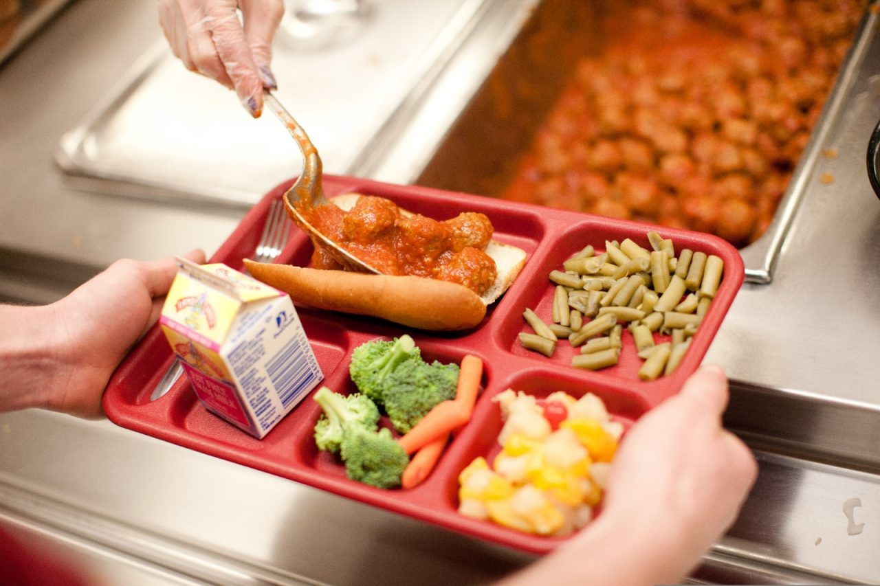Student being served lunch on a tray in the cafeteria.