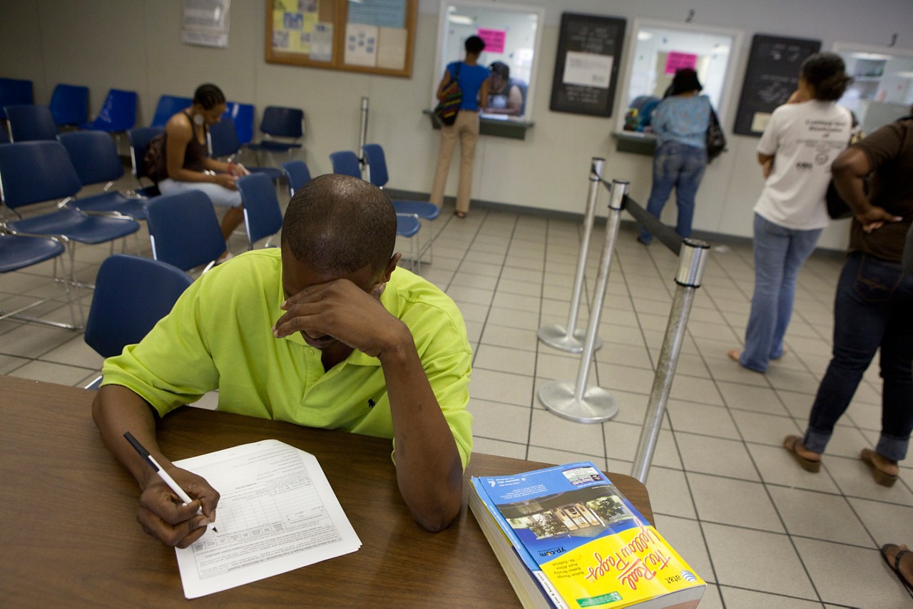 One man, one white woman, ages 25-35, collaborating using mobile devices, laptop, paperwork.