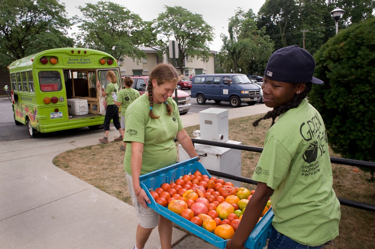 High school students carrying a bin of produce.