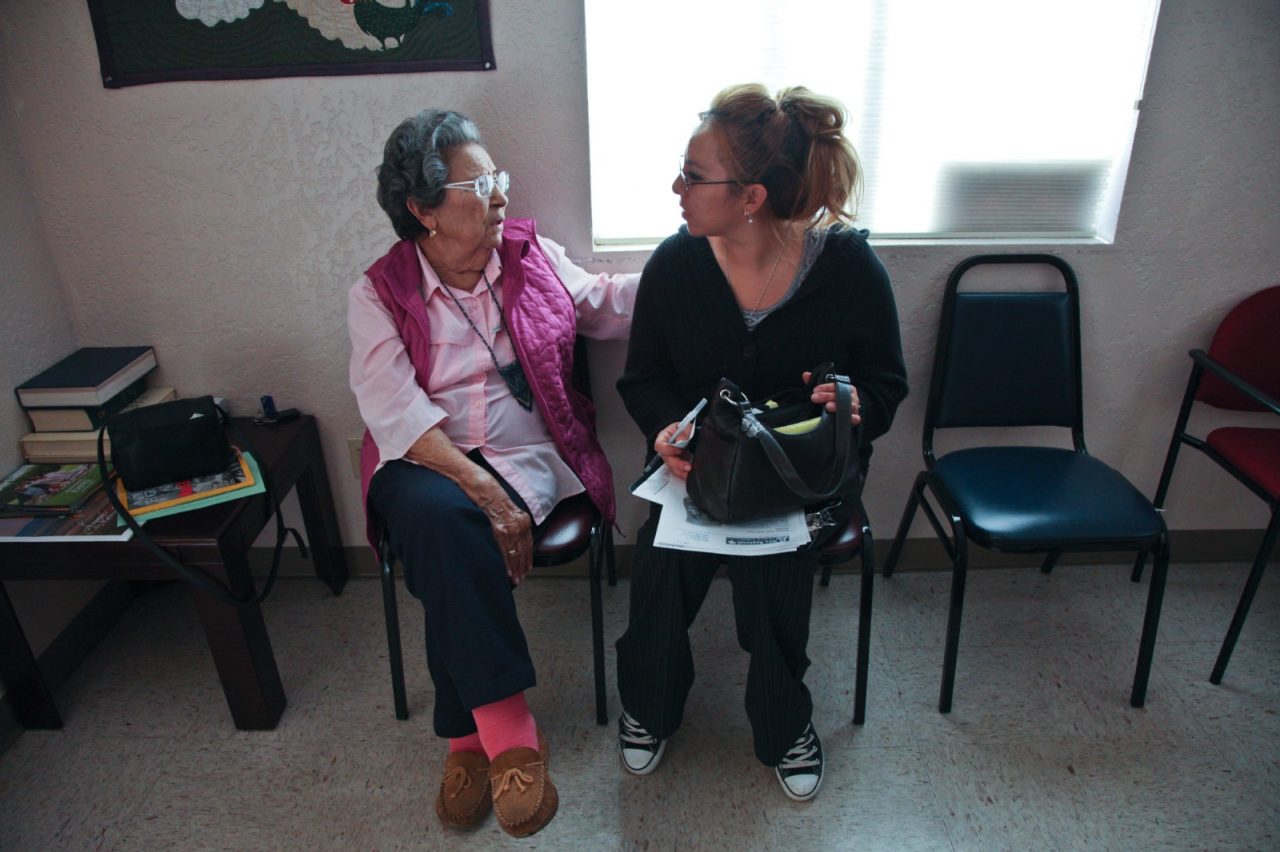 A woman takes a patient's blood pressure.