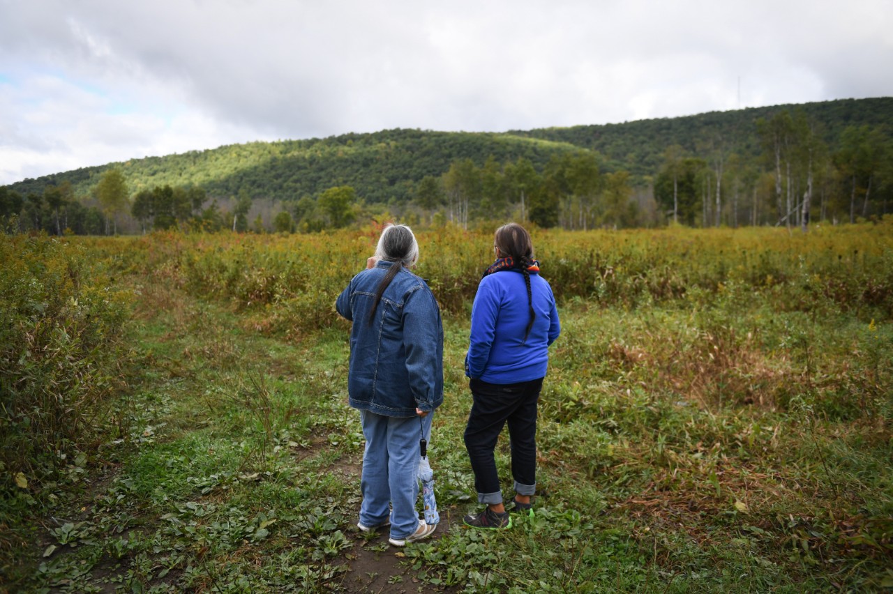 Two women standing in a field.