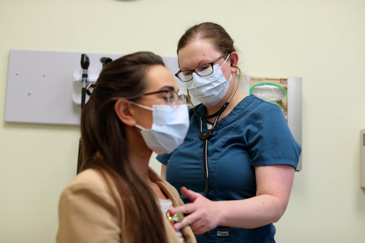 CHICKALOON, ALASKA - SEPTEMBER 28, 2021: Nurse Practitioner Sarah Ferroni and patient Brittany Reed in the C’eyiits’ Hwnax Life House Community Health Center.
