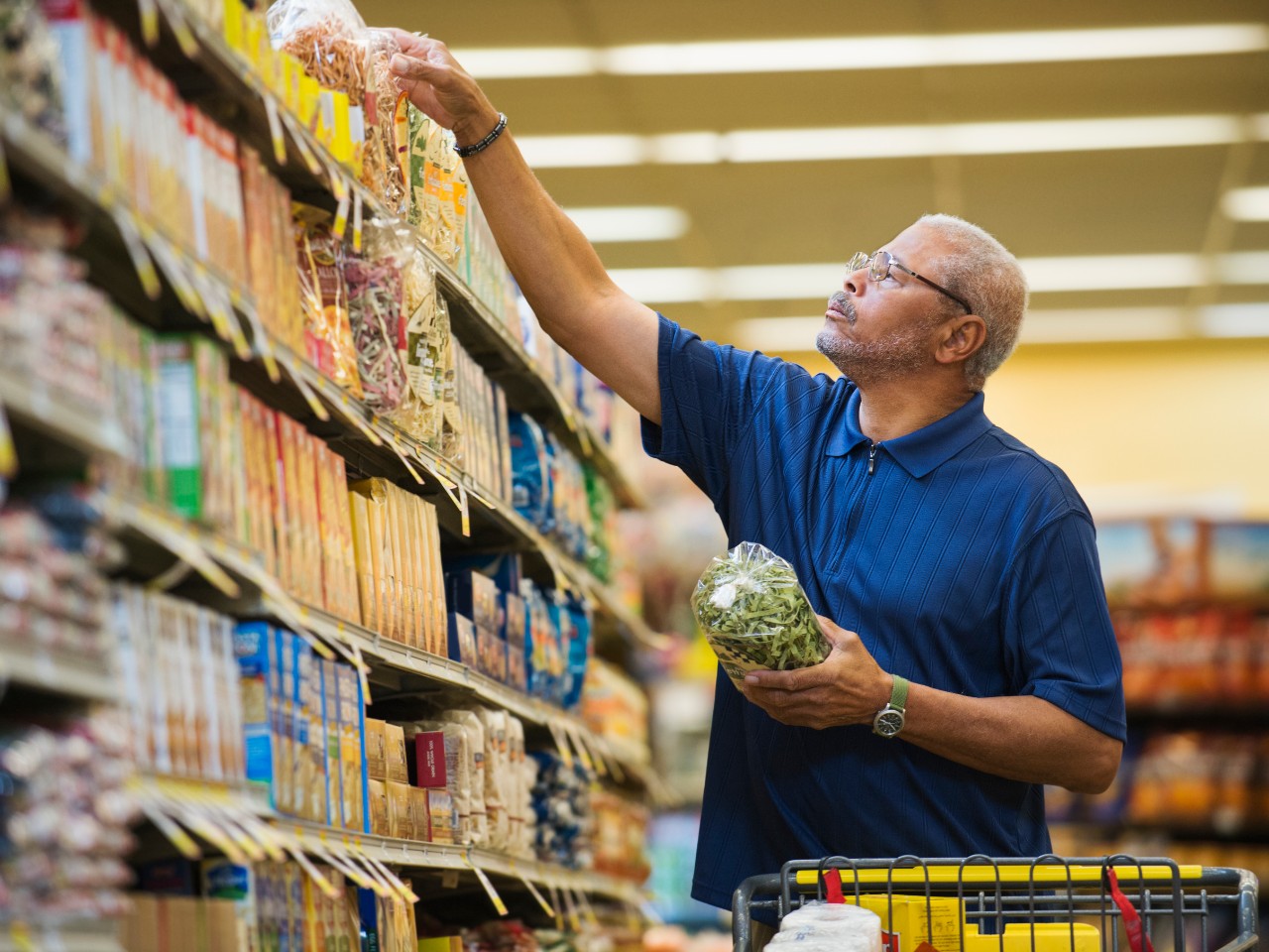 Older man shopping in grocery store.