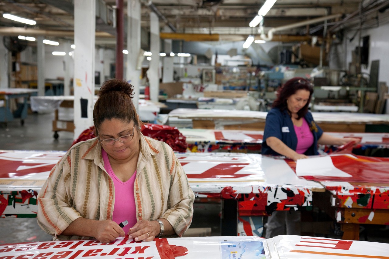 Women working to fabricate promotional banners.