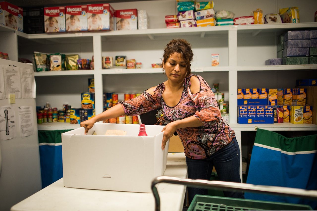A woman bagging food in a food pantry.