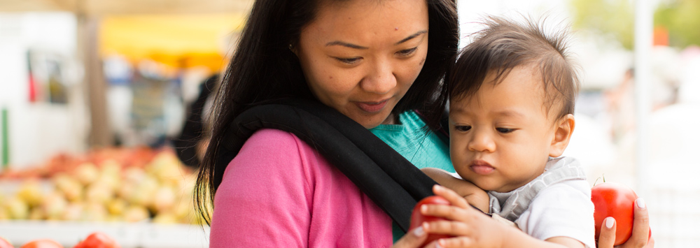 A woman and her baby at a farmers' market.