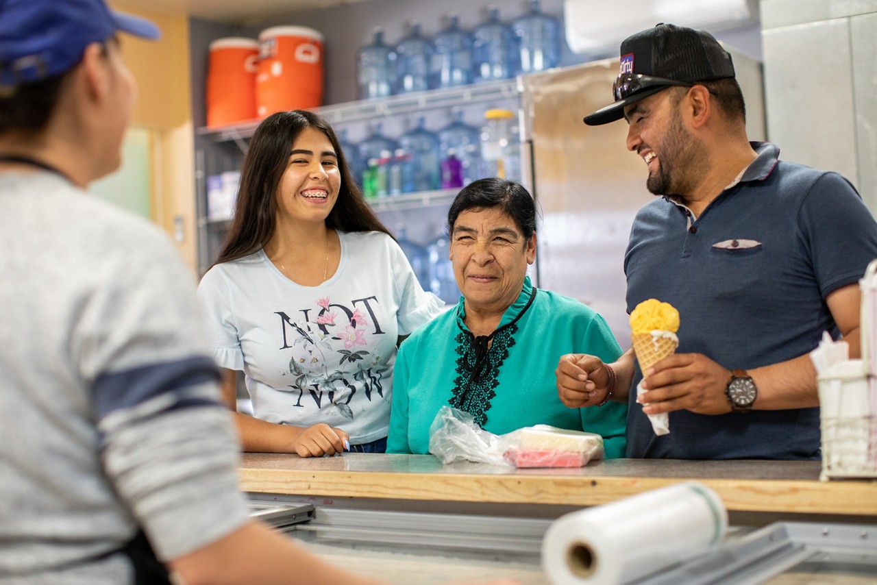 A happy family ordering at an ice cream counter. 