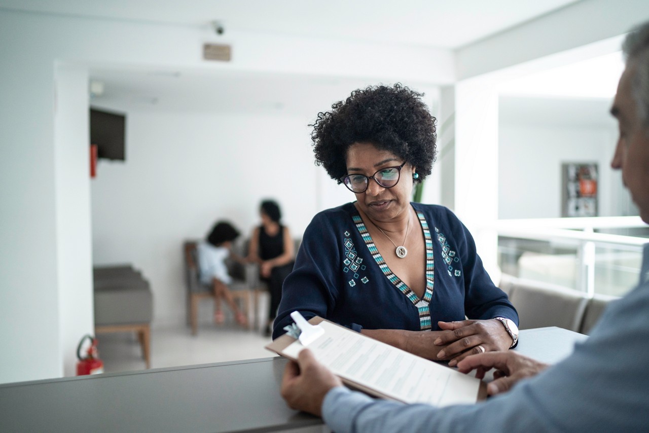 Patient talking to the secretary at hospital reception