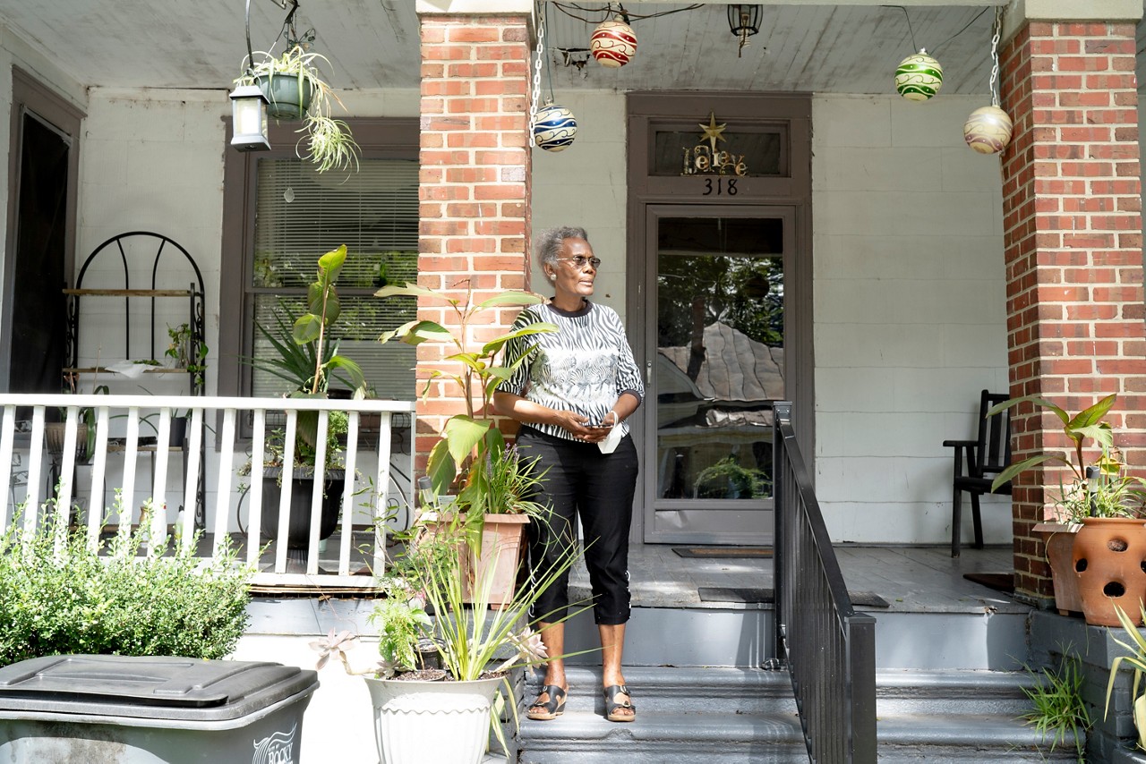 A homeowner standing on her front porch. A homeowner standing on her front porch.