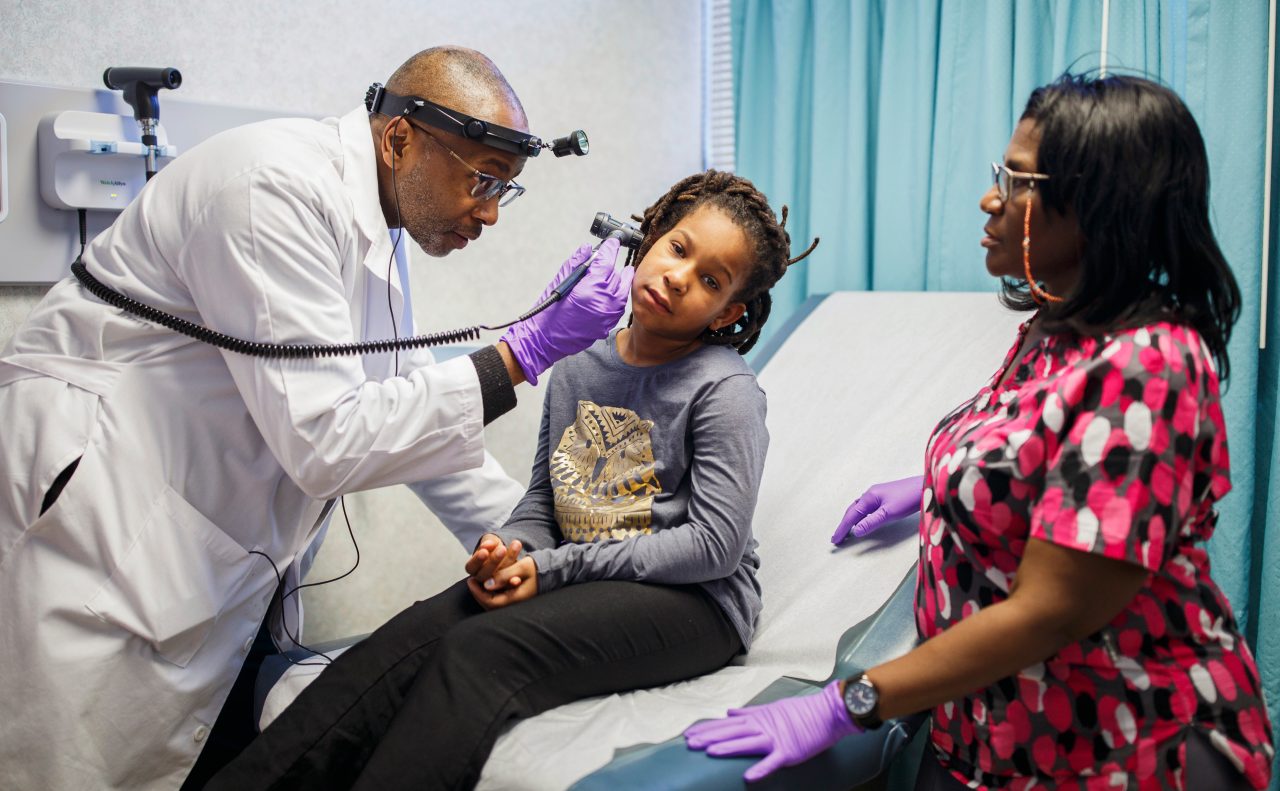 Dr. Charles Moore examines 8-year-old patient NeQuasia Hartfield as Rhonda Mitchell stands by to assist at the HEALing Community Center in Atlanta, Ga. on Wednesday, March 14, 2018.