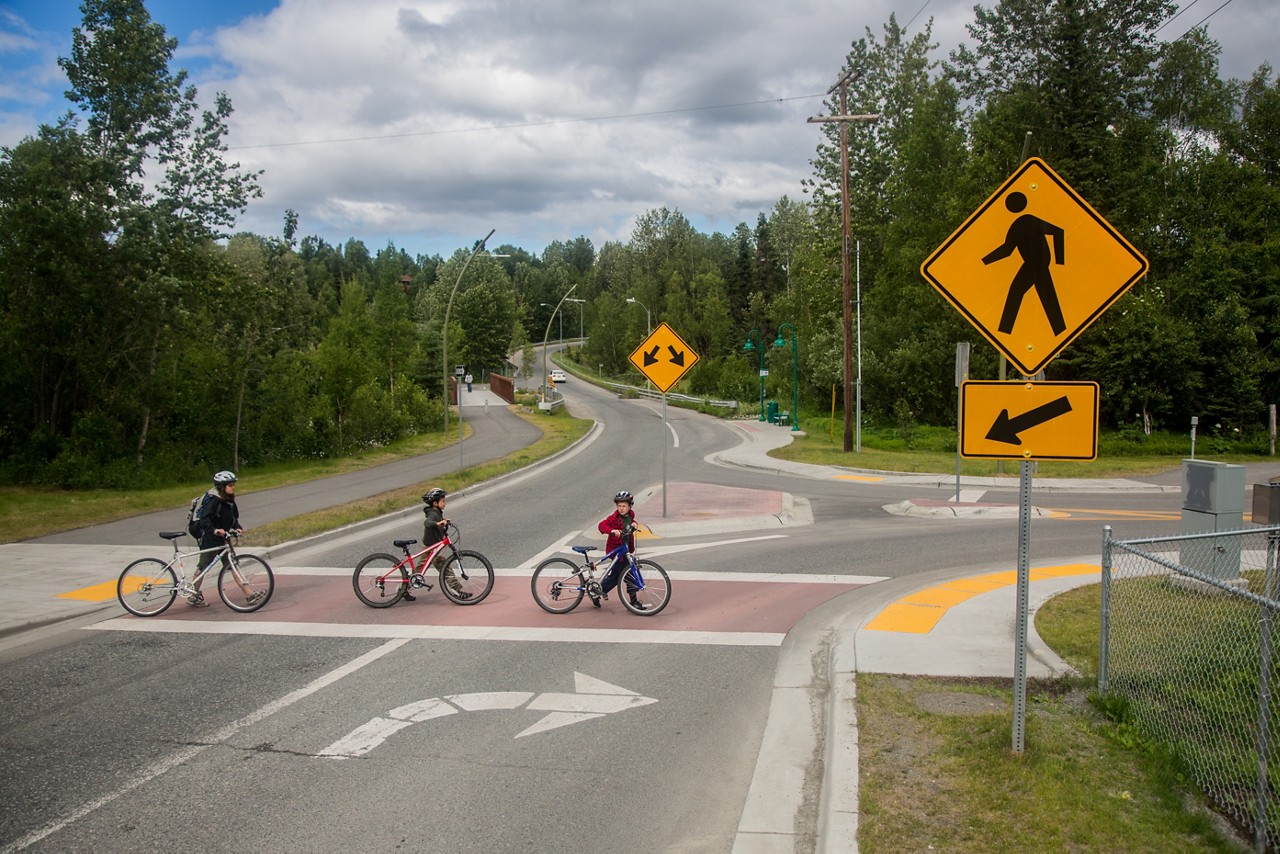 Three cyclists crossing the street. 