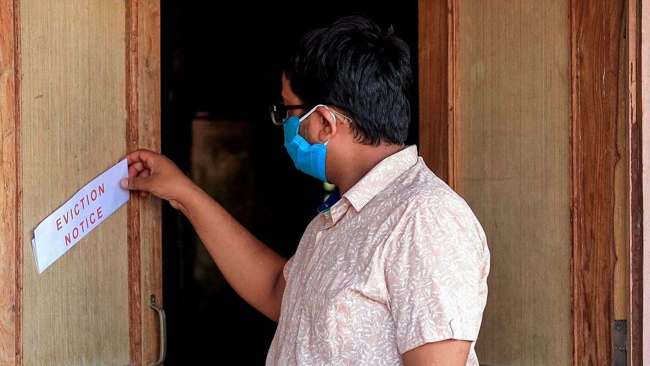 A man finds an eviction notice on his home.