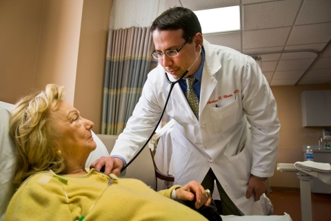 A doctor meets with his patient in a cancer center. 