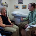 A doctor talks to a patient in an examination room. thumbnail