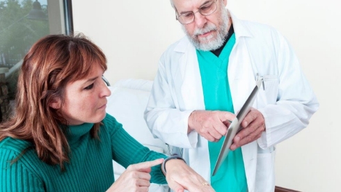 A patient goes over app-based data with her clinician.